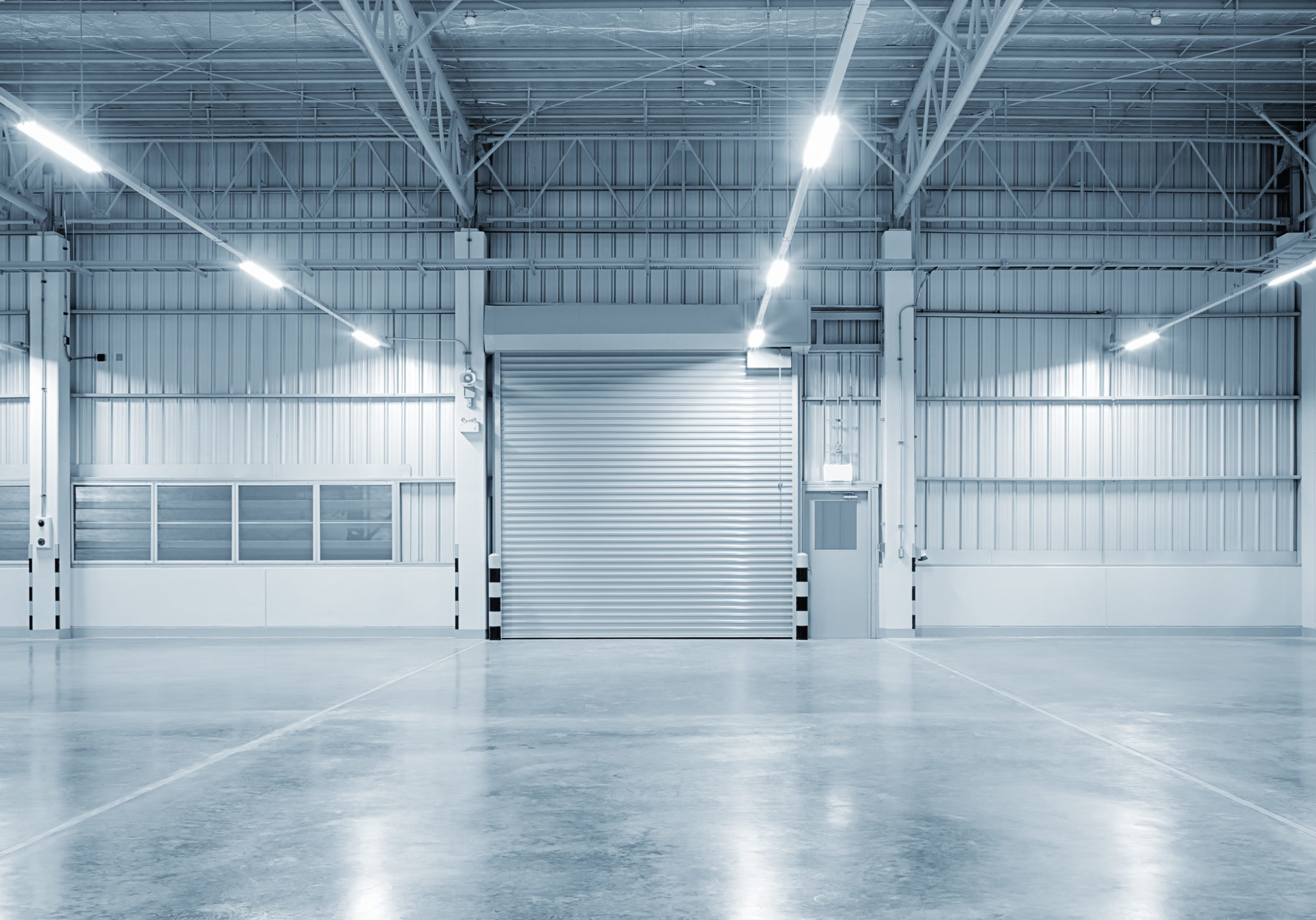 Roller shutter door and concrete floor outside factory building for industry background.